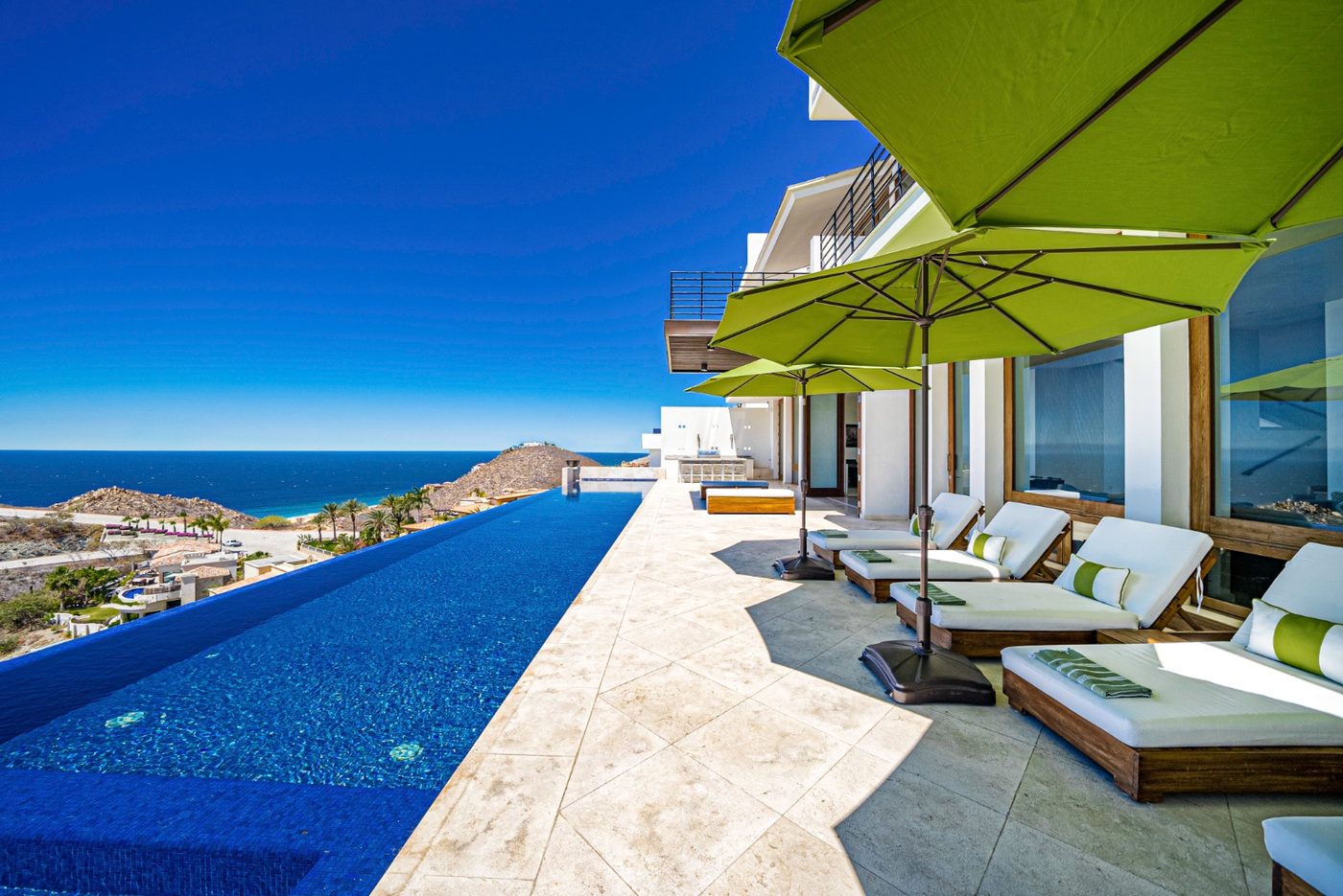 Infinity pool deck with chaise lounges and umbrellas