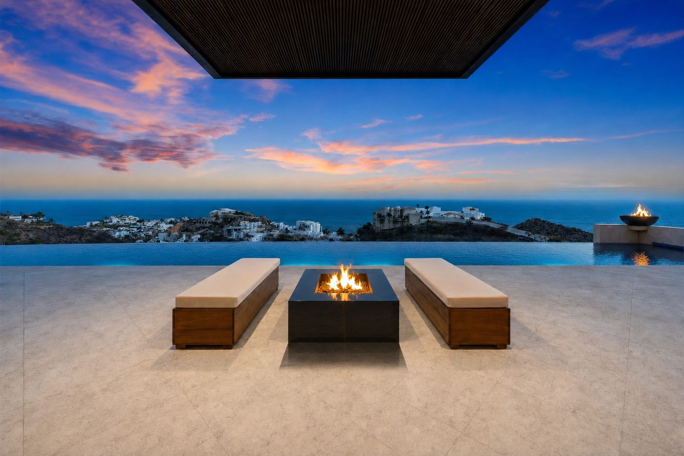 Infinity pool deck at sunset with twin benches and fire bowl