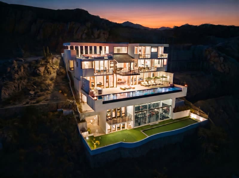 Villa Savina at twilight, lit across all five levels above the Pedregal cliffside